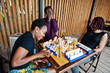© AS Photo Family - Group of three african american friends play table games.