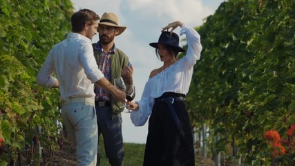 Wall Mural - Attractive hipster friends dancing with joy enjoying summer holiday winetasting event at vineyard. Party degustation. Drunk people.