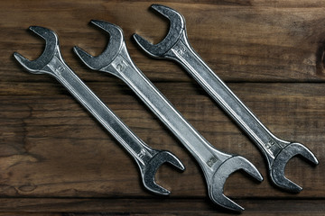 Wall Mural - set of wrenches on a wooden background, place for an inscription	