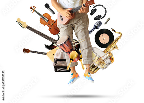 Fototapeta instrumenty muzyczne  mlody-czlowiek-gra-na-gitarze-wsrod-instrumentow-muzycznych