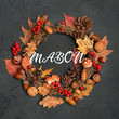 mabon holiday traditional wreath. autumn wreath with mushrooms, fall leaves, red berries, acorns on dark background. autumn holiday, fall, thanksgiving, halloween concept. Flat lay