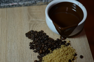 White cup, coffee beans and liquid chocolate