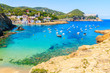 View of beach in Sa Tuna fishing village with boats in sea bay, Costa Brava, Catalonia, Spain