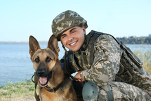 Man In Military Uniform With German Shepherd Dog Near River