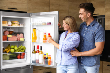 Sticker - Couple taking bottle with juice out of refrigerator in kitchen