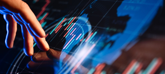 Businessman is pointing on a hi technology futuristic digital screen with financial analytics