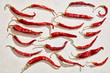 Sun dried red hot chili peppers under harsh sunlight with white stone background.