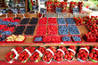 Fresh blueberries, raspberries, blackberries and strawberries displayed on an outdoor market stall