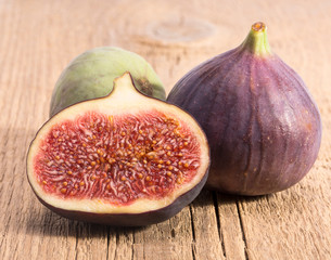 Fresh figs, half and whole on wooden plank, close up. Food photo