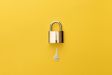 Top View Of Padlock And Key On Yellow Background