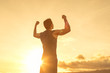 © kieferpix - Strong confident man flexing his arms facing the sunset.