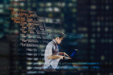 young male student in school uniform sitting on a floor of an office while coding for a website, vie