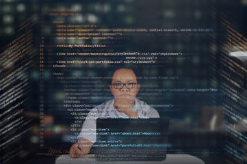 young it male student reading his html codes projected on a virtual hologram screen with his laptop 