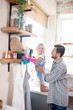 © zinkevych - Smiling dad lifting daughter while dusting shelves