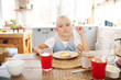 © zinkevych - Beautiful girl sitting at the table while having breakfast