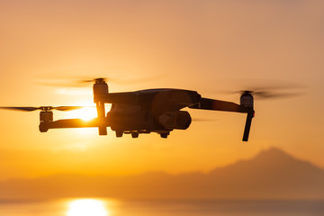 Wall Mural - A drone takes a panorama on the background of the holy Mount Athos at sunrise in the summer. The lights of a sun. Beautiful silhouette of Mount Athos in Greece in the Aegean Sea. Calm seawater