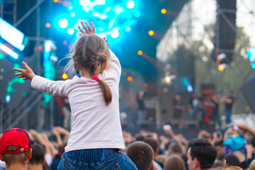 Children sit around the neck at a street concert