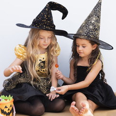 Front view little girls sitting on floor on halloween