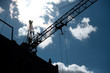Construction site. Workers  and crane silhouette during development of the biulding