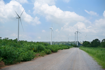 Wall Mural - Wind turbine in green field with cloud and blue sky