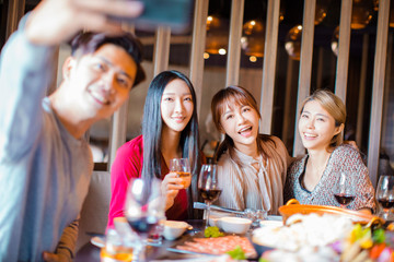 Wall Mural - Happy friends taking selfie in hot pot restaurant