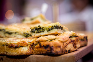 Little stuffed pizza with pork sausages and friarielli broccoli on the wooden board, Typical Neapolitan food