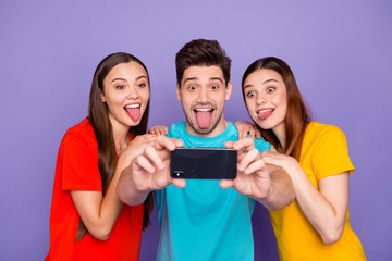 Poster - Portrait of three nice attractive lovely charming crazy childish cheerful cheery glad guys wearing colorful t-shirts taking making selfie having fun isolated over violet lilac background