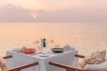 Romantic Dinner On The Beach. Wine Glasses Next To A Beautiful Dinner Table Setting, Luxury Resort Hotel At Beach View