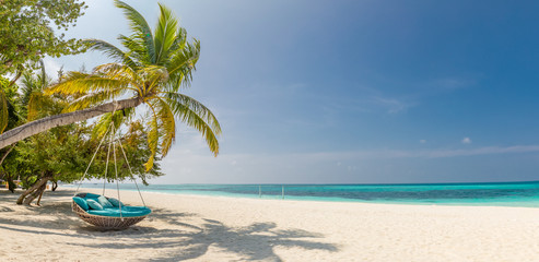 tropical beach panorama as summer landscape with beach swing or hammock and white sand and calm sea 