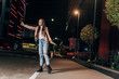 © LIGHTFIELD STUDIOS - attractive woman in pink jacket hitching and smiling in night city