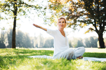 Frau macht Meditationsübungen im Park 