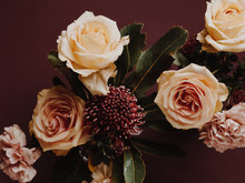 Close Up Shot Of Floral Arrangement In Autumn Colours With Roses, Carnations And Protea
