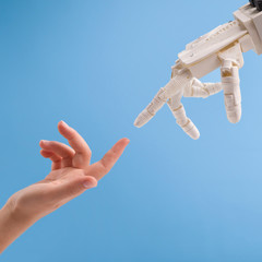 Poster - Female and robot hands reaching to each other on blue background