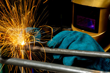 A craftman is welding with workpiece steel.Working person About welder steel Using electric welding machine There are lines of light coming out and safety equipment in factory industry..