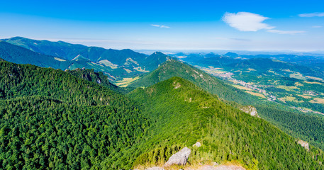 Slovakia national parkland Mala Fatra - view from Maly Rozsutec mountain to nearby hills and valleys. Sunny summer day, tourism and hiking in fresh and pure nature. Forest and green trees.