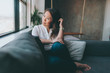 © CM Photo - A beautiful asian woman sitting on the couch while looking out the window.