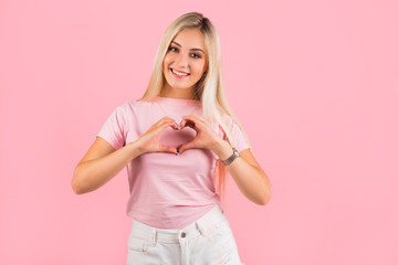 beautiful young woman on pink background with hand gesture