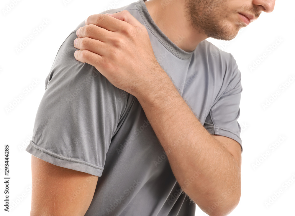 Young man suffering from pain in shoulder on white background, closeup