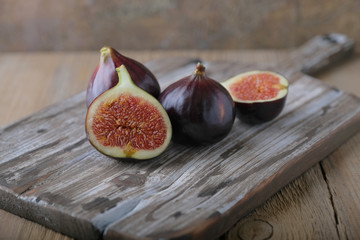 Fresh ripe figs and cut in half on a wooden table.