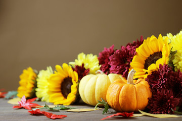 Autumn background with pumpkins and beautiful colorful flowers.