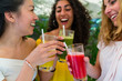 © Westend61 - Three happy young women toasting with healthy drinks