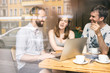 © Westend61 - Group of friends sitting together in a cafe with laptop