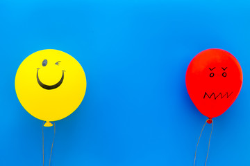 Wall Mural - Treat depression concept. Balloons with frustrated and smiling faces on blue background top view copy space