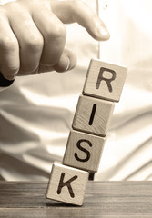 Wall Mural - man removes blocks with the word risk. the concept of reducing possible risks. insurance, stability 