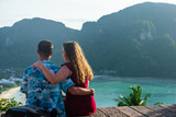 Fototapeta  - couple sitting on the edge of cliff