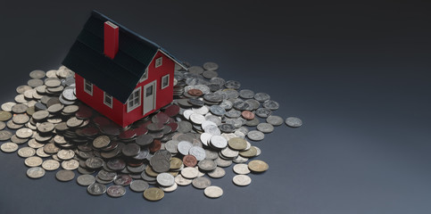 Wall Mural - Red small house model on stack of coins with black background