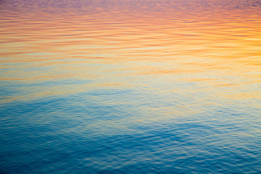 clear water texture in blue and orange. background of the ocean and the sea backlit by the sun. soft