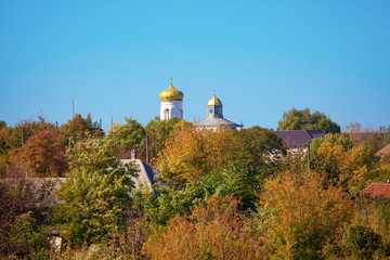 Wall Mural - autumn image with church in the village 