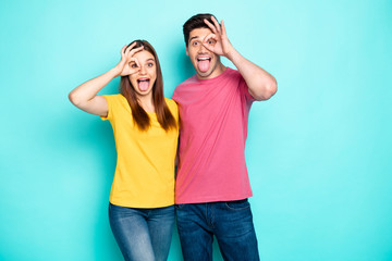 Portrait of his he her she nice attractive lovely crazy cheerful cheery couple hugging showing ok-sign like glasses having fun isolated over bright vivid shine vibrant green turquoise background