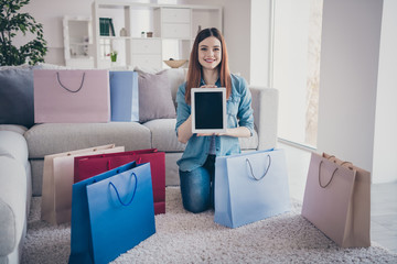 Sticker - Full length photo of pretty positive addicted redhair lady sit on floor carpet with many bags like online order show tablet advertise wear denim jeans lifestyle clothes house indoors